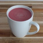 Cup of pink Beetroot Latte standing on counter