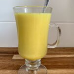 Turmeric Latte in a glass cup on a wooden counter