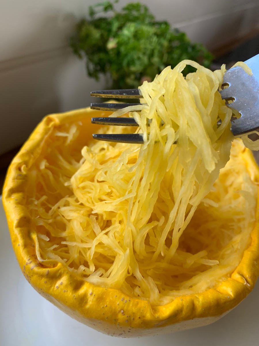 Microwaved spaghetti squash served in its shell, with fork pulling strands