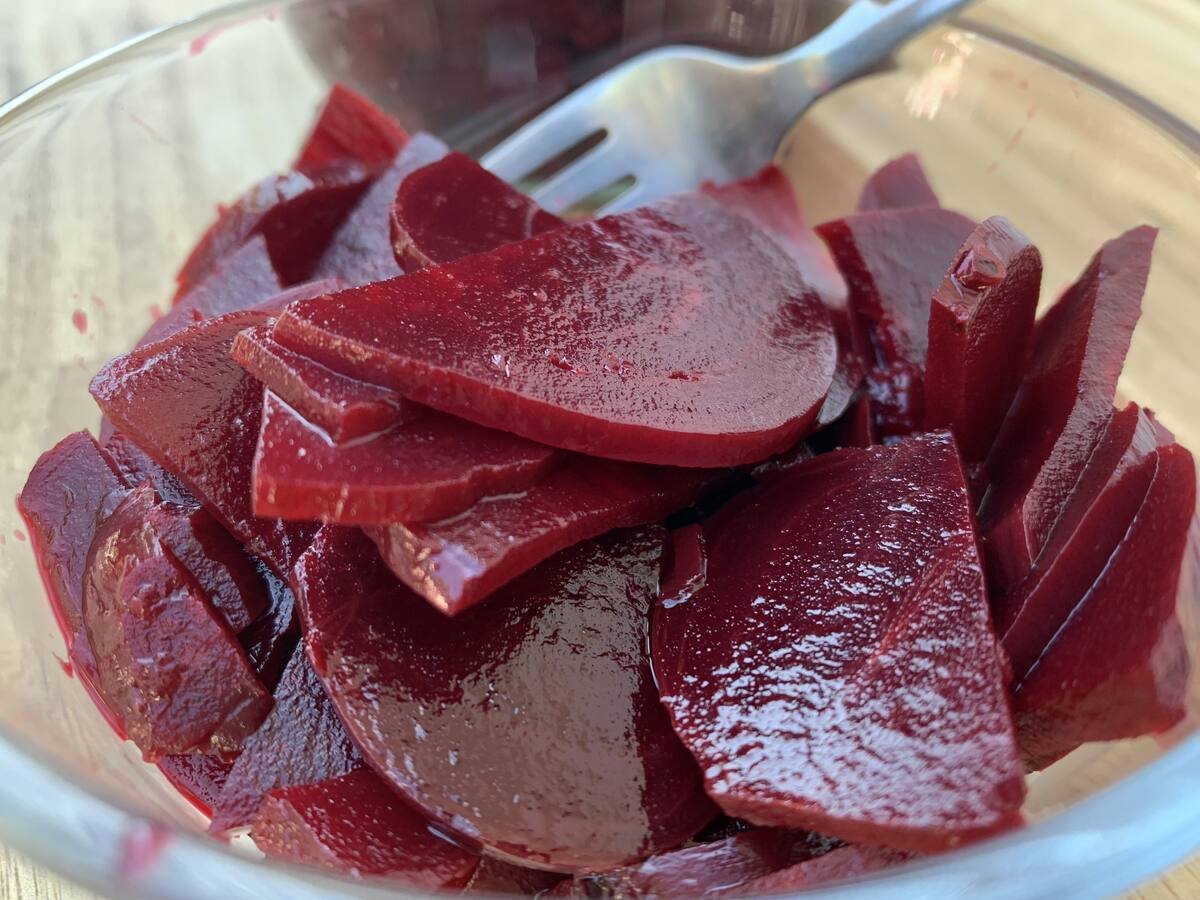 Gladd bowl of pickled beets with a fork. Pickled beets are AIP compliant with only honey and are free of refined sugar.