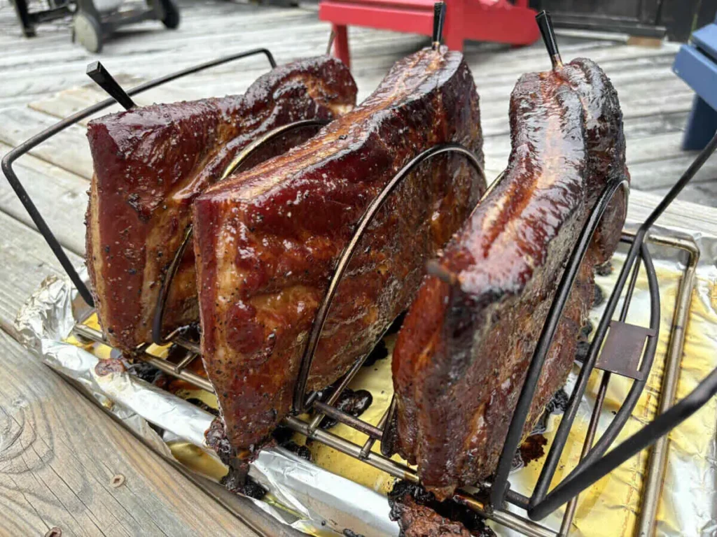 Smoked AIP bacon on a rack, with a beautiful golden-brown glaze after hours of slow cooking.