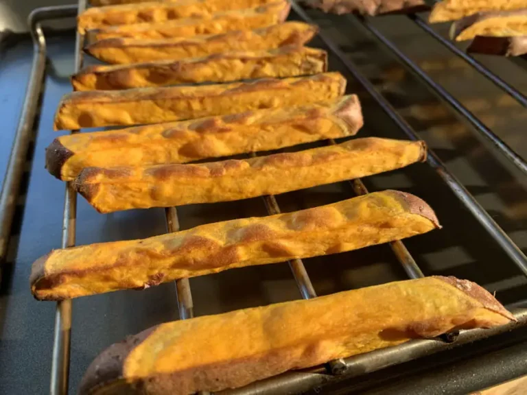 Golden baked sweet potato fries on a grid.