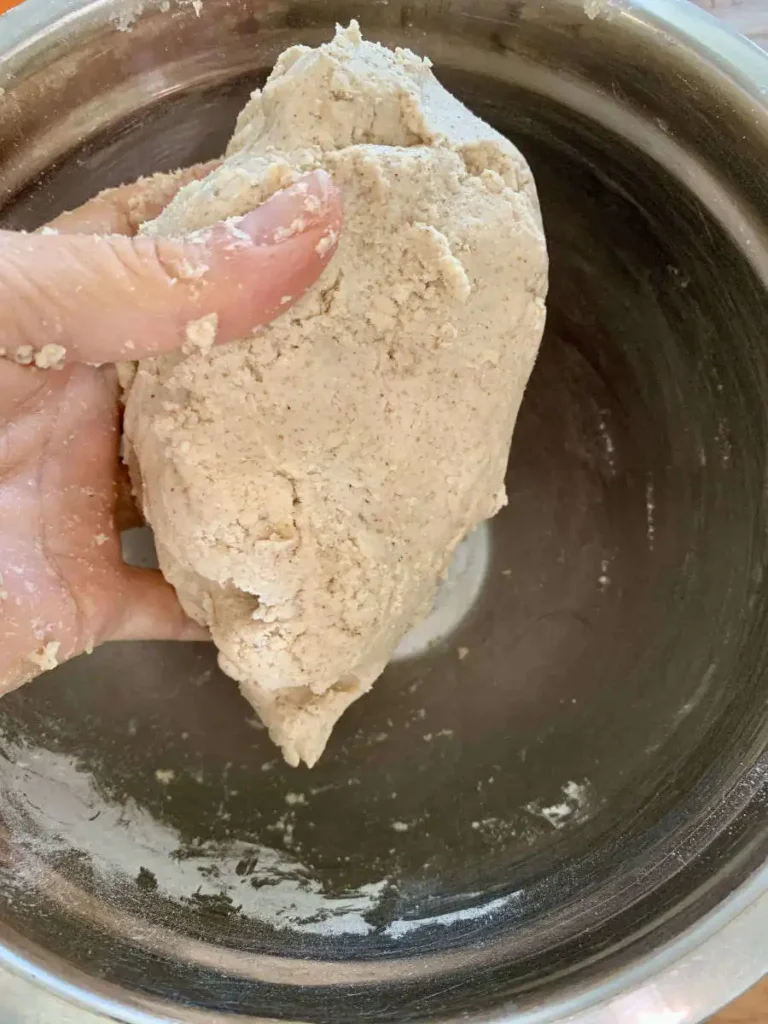 Hand holding a ball of AIP pie dough