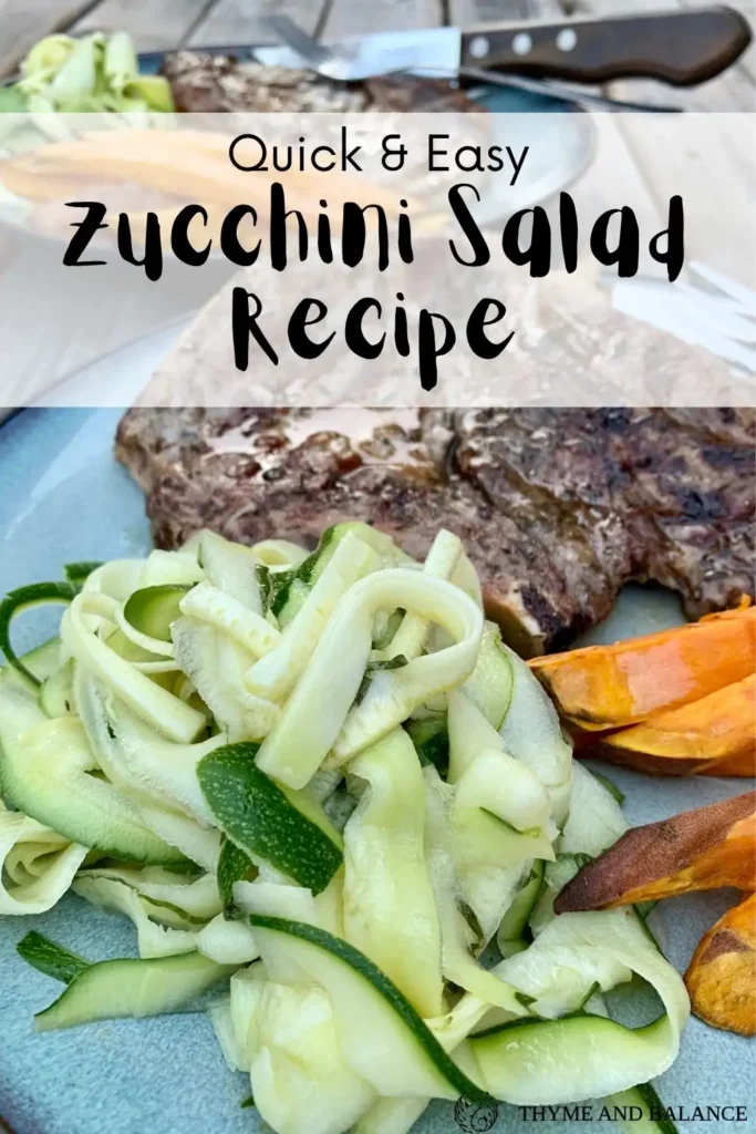 A plate of zucchini ribbon salad beside grilled pork chops and oven baked sweet potato fries.