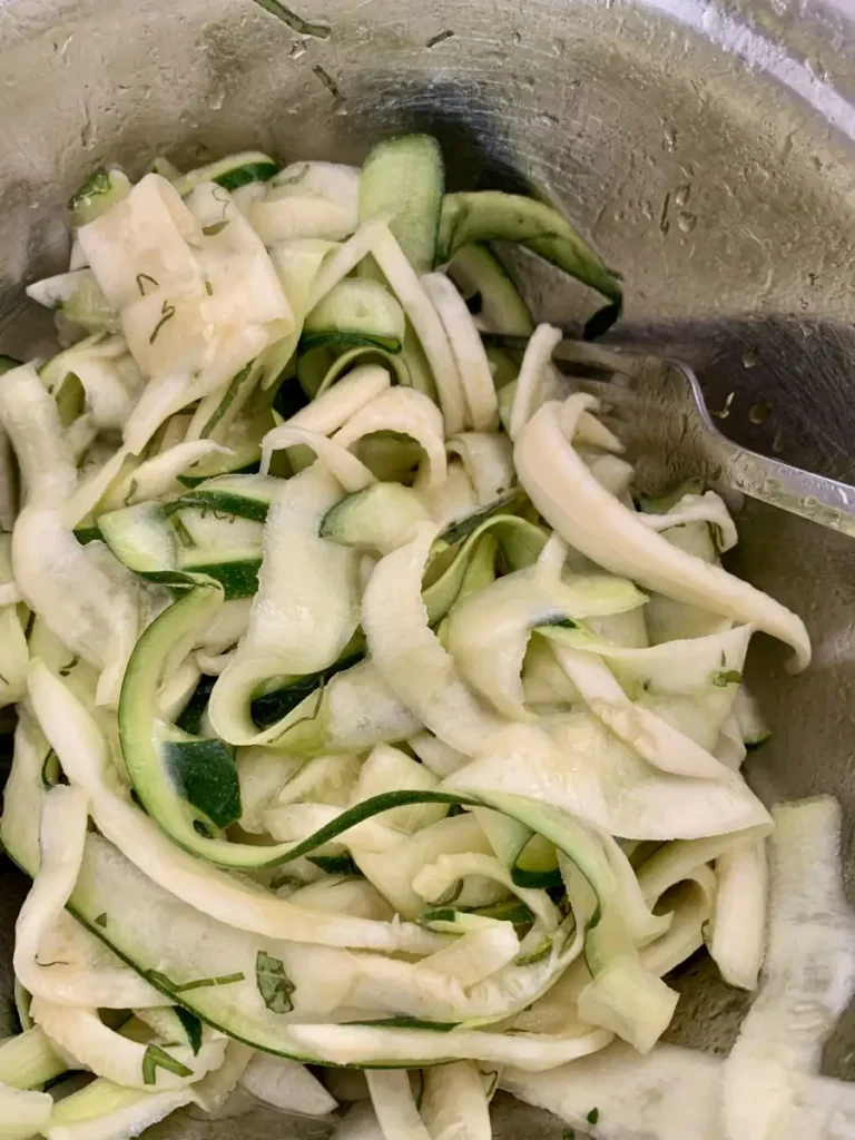 bowl with zuchini ribbons tossed in salad dressing