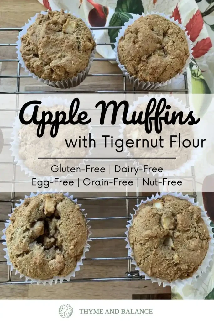 Muffins lying on a cooling rack on a wooden counter with a dish towel. Text overlay reads: Apple muffins with tigernut flour. Gluten-free, grain-free, dairy-free, egg-free and nut-free