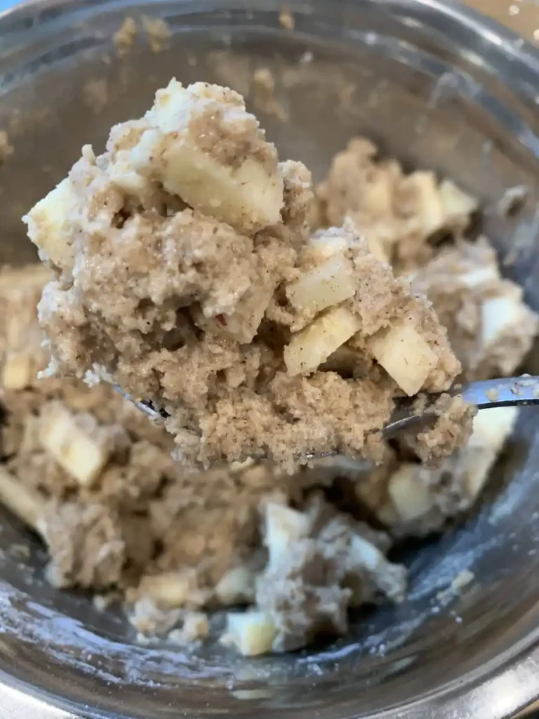 Apple muffin batter in a bowl ready to be distributed into a muffin tray.