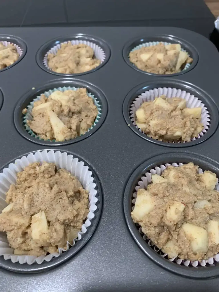 Mixed muffin batter distributed in a muffin tray before baking