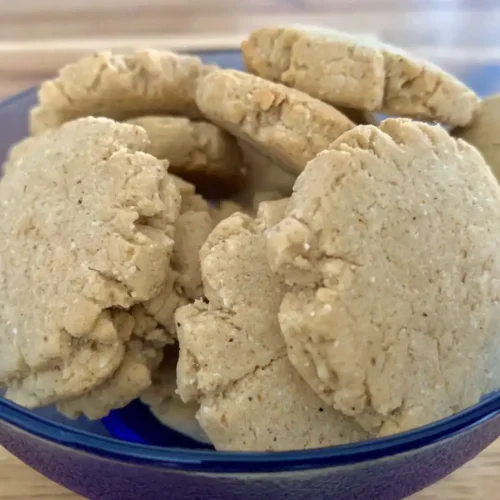 AIS shortbread cookies in a blue glass bowl on a wooden counter
