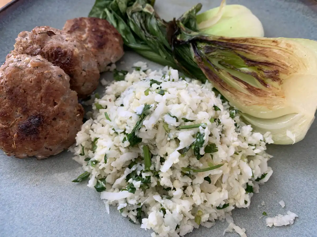 Plate filled with cauliflower rice, breakfast sausage and charred bok choi.